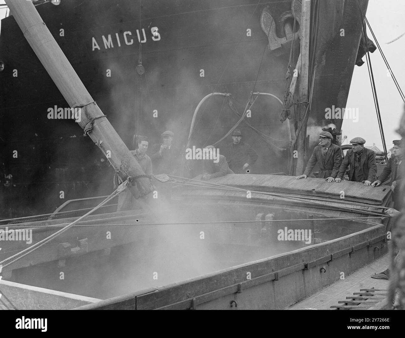 Non così Dusty. Una foschia di polvere bianca sorge dalla stiva di una chiatta del fiume londinese come ricco grano australiano, il primo da prima della guerra, viene scaricato dalla nave cargo Amicus a Millwall oggi (lunedì). 16 febbraio 1948. Foto Stock