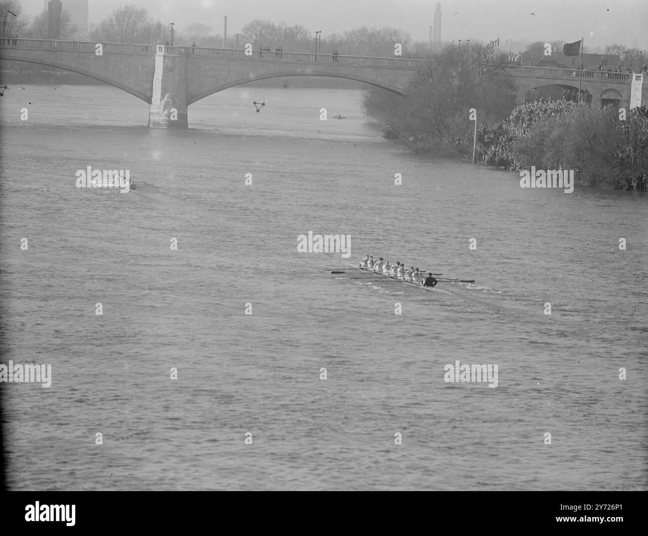 La folla delle vacanze di Pasqua ha fiancheggiato il percorso da Putney a Mortlake oggi (sabato), per assistere al più grande spettacolo gratuito di Londra, la 94a gara di barche inter-Varsity tra Oxford e Cambridge. La foto mostra: '50th win' il vittorioso equipaggio di Cambridge supera il traguardo cinque lunghezze davanti alla barca Oxford dopo la fila record dell'estenuante percorso di 4 1/2 miglia. 27 marzo 1948 Foto Stock