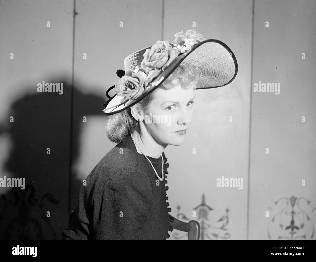 Visto alla Easter Bonnet Parade delle ultime creazioni di sei eminenti designer di moscheria londinesi, questo cappello da immagine di Livorno naturale, bordato di velluto nero. Le rose rosse e i delicati gigli della valle formano la decorazione floreale di questo esempio di 'moschettoni per maggio'. 3 aprile 1948. Foto Stock