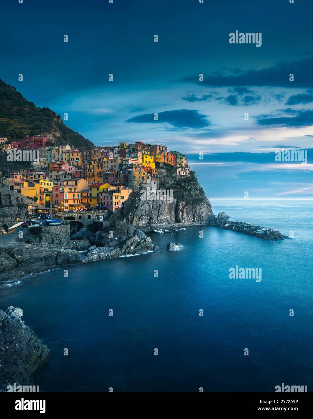 Manarola villaggio sulle rocce nell'ora blu, paesaggio marino nel Parco Nazionale delle cinque Terre, regione Liguria, Italia, Europa. Foto Stock