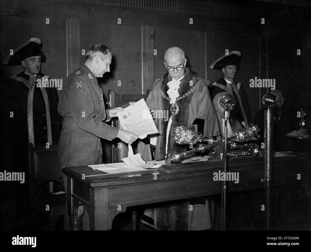 Libertà di Hastings conferita al feldmaresciallo. Visconte Montgomery di Alamein oggi. Quando il sindaco consigliere F.. W Chambers gli presentò un pezzo di targa con i nomi delle sue vittorie ornato con immagini in smalto delle navi da combattimento cinque porte, sormontate da una figura dorata di San Michele (santo patrono di Hastings) spettacoli di immagini; visconte Montgomery che riceve la libertà del Borough dal Maher, Cllr Chambers in una riunione speciale del consiglio comunale presso il padiglione di roccia bianca. 8 marzo 1946 Foto Stock