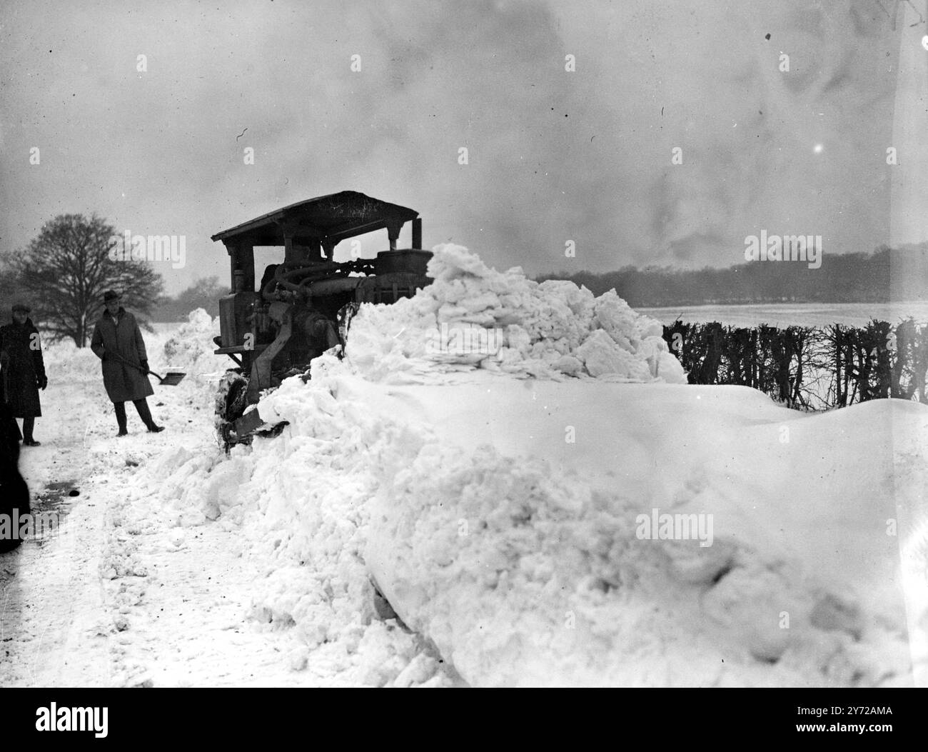 Le tempeste di neve si sono abbattute in Gran Bretagna questo fine settimana e il sud-est dell'Inghilterra è stato il più colpito. Molte strade nella zona del Surrey e del Kent erano impraticabili a causa della pesante caduta di neve. Le immagini mostrano: Un Bulldozer che sgombra un tratto di strada di 500 metri tra Caterham e Merstham, vicino a Chaldon, nel Surrey, che ha bloccato la strada a una profondità di 4 piedi. 3 marzo 1946 Foto Stock