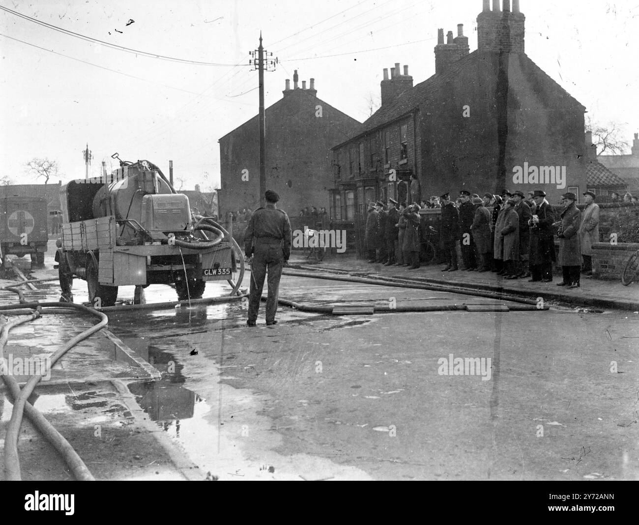 Oggi i rivoltosi hanno dato fuoco al campo di detenzione militare, a Northallerton, Yorkshire. La rivolta si è svolta nello stesso blocco di edifici in cui un certo numero di prigionieri ha iniziato un ammutinamento due settimane fa, quando 16 prigionieri sono fuggiti. Le immagini mostrano: La folla guarda i pompieri che lavorano fuori dalla prigione. Marzo 1946 Foto Stock