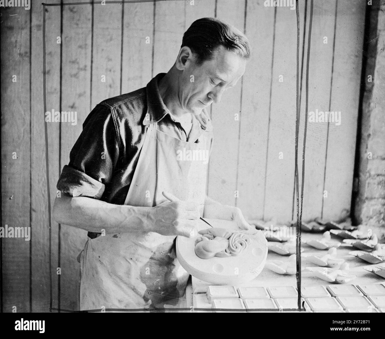 Ceramica Poole per la Principessa. Ottimi esempi di ceramica di Poole, comprendente un servizio di cena di 50 pezzi, disegnato da John Adams, e un lucente rialzato con manici bianchi di Magnolia, disegnato dalla signora Truda Carter, saranno presentati alla principessa Elisabetta in occasione del suo prossimo matrimonio da parte del Borough di Poole, Dorset. Spettacoli fotografici, Josef Noivok, un ceramista polacco, impiegato a Poole, visto al lavoro su una delle maniglie del vaso di presentazione. Sono nel disegno di cani cinesi. 7 novembre 1947 Foto Stock