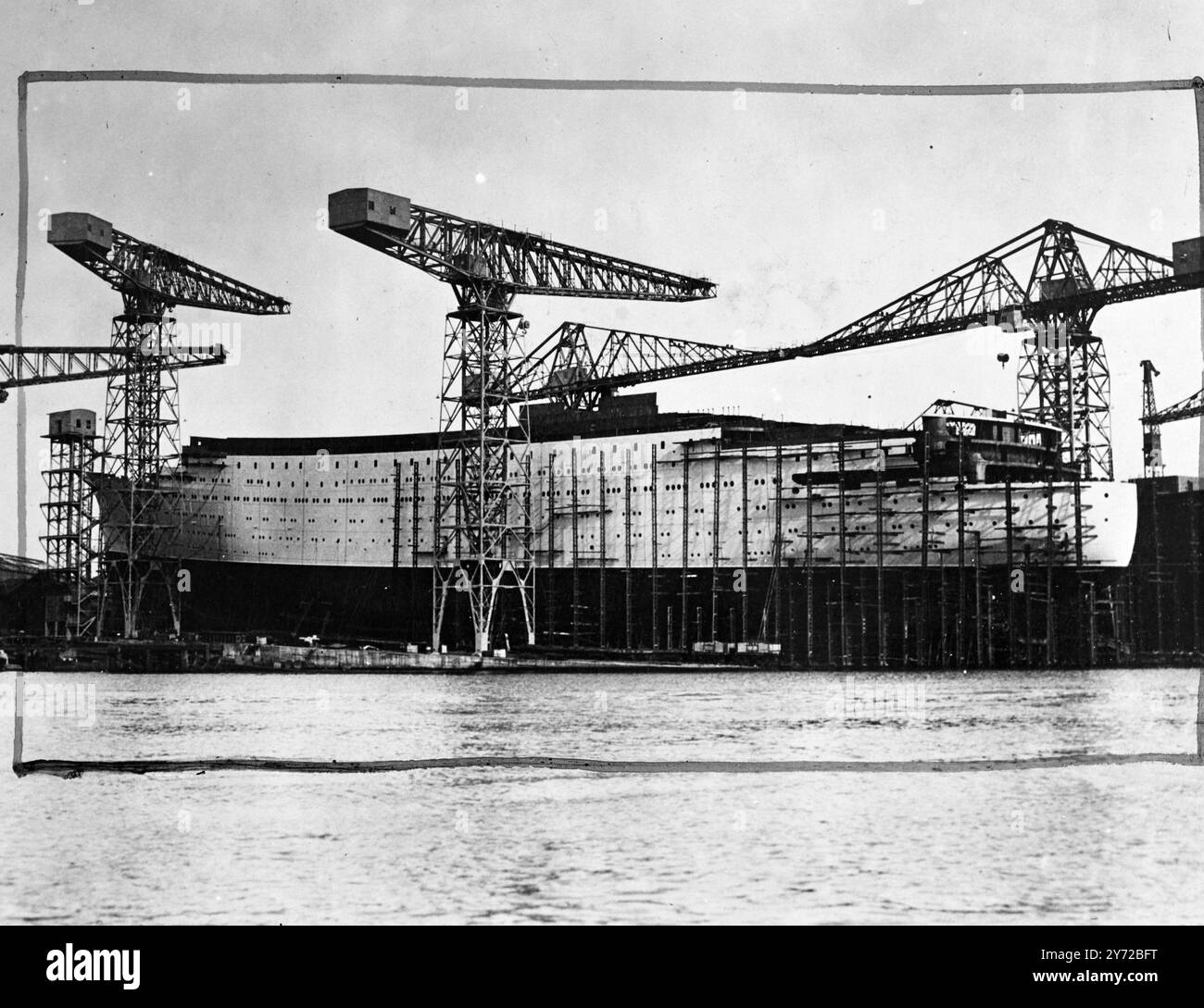 Per essere lanciato dalla principessa Elizabeth. La nave più grande costruita al mondo attualmente, la Caronia, e la più grande nave mercantile a lasciare le scorte di Clydebank da quando la "Queen Elizabeth" sarà varata da sua altezza reale la Principessa Elisabetta il 30 ottobre. Le catene di trascinamento utilizzate per il lancio di quelle grandi navi "Queen Mary" e "Queen Elizabeth" saranno di nuovo in servizio quando questa nuova nave Cunard White Star da 34.000 tonnellate scenderà dallo scalo al cortile di John Brown. Spettacoli fotografici, per 34.000 tonnellate di linea Caronia raffigurata nelle scorte del cantiere John Brown, Clydebank, pronti per il lancio di questo mese da Pr Foto Stock
