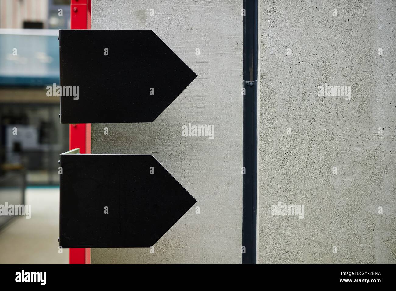 Foto di sfondo di due frecce nere come parte di elementi di design minimalista del moderno business center caratterizzato da uno stile brutale e pareti in cemento, spazio fotocopie Foto Stock