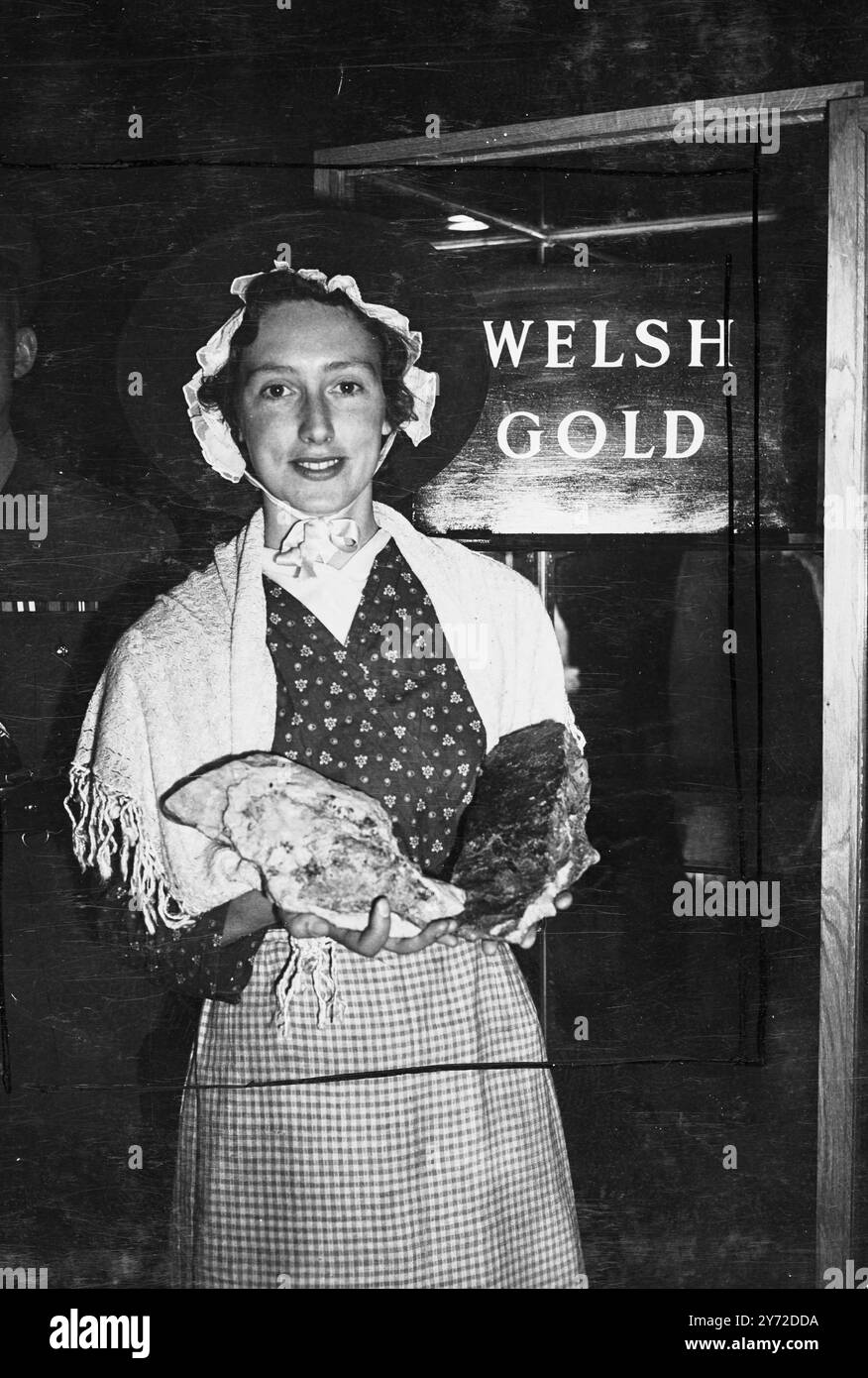 Per diventare un anello di nozze reale?. - Il minerale d'oro della miniera di Graigwen, vicino a Barmouth, l'unica miniera d'oro, che ora lavora in Galles, è stato inviato oggi all'Industrial Wales Exhibition di Olympia per essere messo in mostra. E' stato offerto per la realizzazione dell'anello della principessa Elisabetta. L'oro gallese, attraverso la tradizione, ha la particolarità di essere usato per le fedi nuziali della famiglia reale britannica. L'ultimo anello di questo tipo fu fatto per la duchessa di Kent. - Mostre fotografiche, Miss Ann Dedwydd Roberts, di Barmouth, Galles, raffigurate con il minerale d'oro , che è in mostra alla Industrial Wales Exhibition da oggi Foto Stock