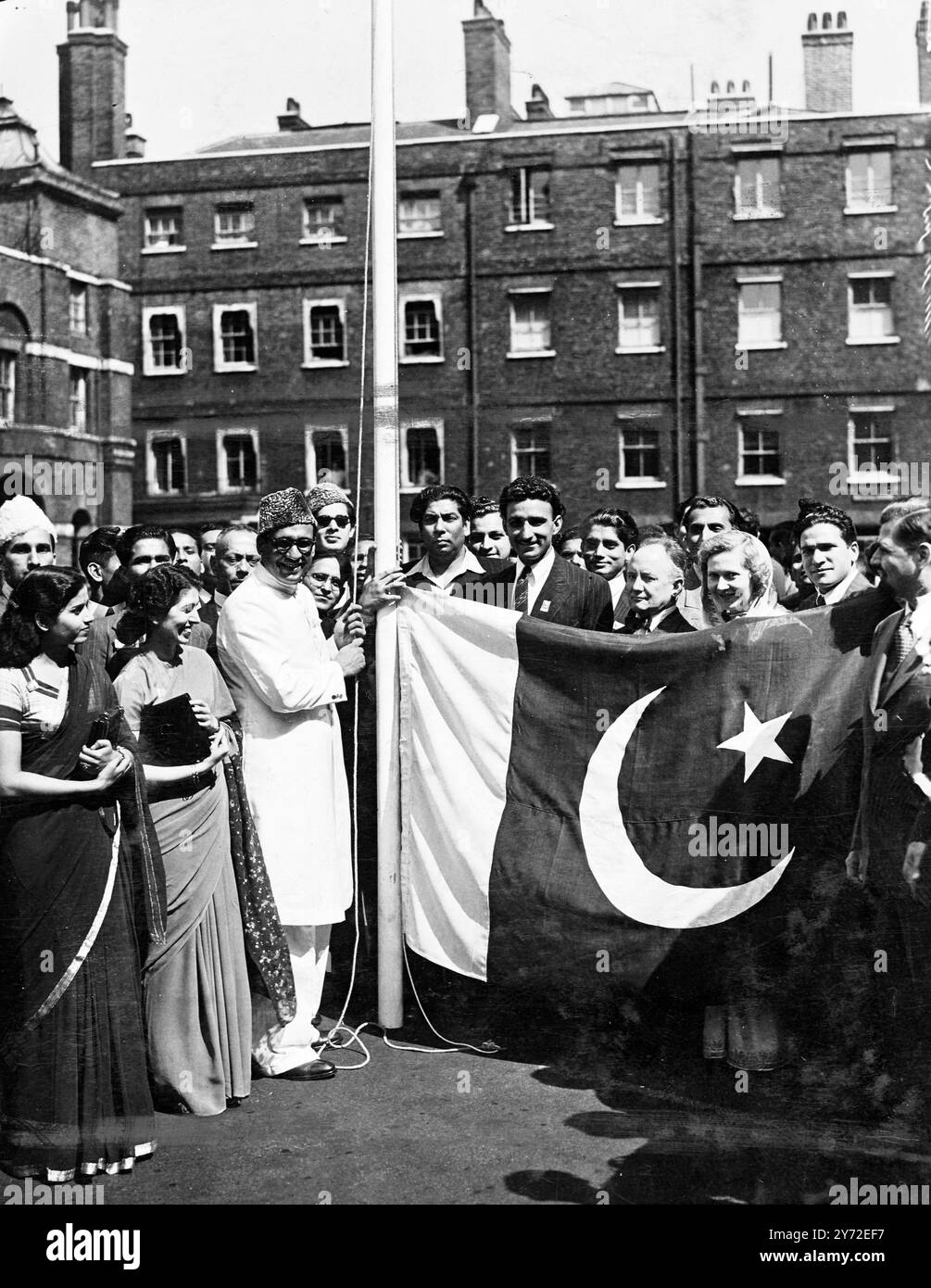 Il primo alto Commissario per il nuovo Stato pakistano, Ibrahim Rahimtoola, ha svelato la bandiera dell'indipendenza presso l'ufficio temporaneo pakistano di Lancaster House, Londra. La nuova bandiera dell'India era stata precedentemente sventolata sopra India House ad Aldwych. A causa della mancanza di alloggi, Rahimtoola non è stato in grado di trovare uffici a Londra adeguati per il suo staff. Per consentire la cerimonia di oggi, il governo britannico gli ha prestato Lancaster House per un solo giorno. Spettacoli fotografici: Guardati dai simpatici sostenitori dell'alto Commissario pakistano (a Flagstaff) è raffigurato con quello pakistano Foto Stock