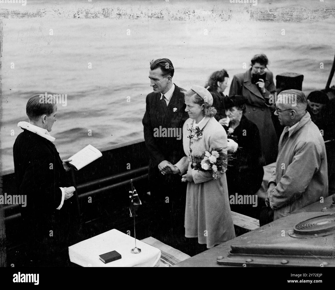 Il ponte scoperto di un rimorchiatore appena fuori dalle acque territoriali britanniche fu la scena del matrimonio della coppia norvegese Johanna Aunne e Wolhart Nilsen. La cerimonia inusuale si svolse perché il matrimonio non poteva svolgersi in Inghilterra senza la presenza di un cancelliere inglese. Il ministro norvegese ha condotto il matrimonio in mare. Diversi ospiti, oltre alla sposa, hanno perso l'aspetto felice associato ai matrimoni, mentre la nave si è gettata in un discreto gonfiore. 11 agosto 1947 Foto Stock
