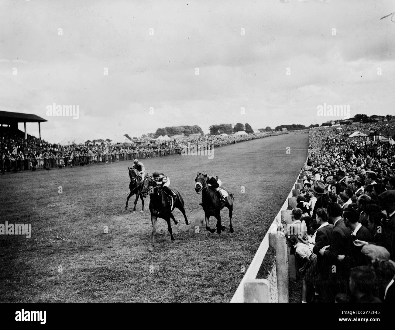 Corse natalizie a Epsom. Durante le festività natalizie, a Epsom Downs c'è una folla enorme per le corse di questo pomeriggio sotto il sole brillante. Spettacoli fotografici, che si avvicinano al termine delle riprese del Earle Dorling Memorial a Epsom oggi (lunedì). Preciptic (centro) è poco più avanti di Portlight (ferrovia più vicina). Portlight è andato avanti e la gara gli è stata assegnata dopo che il giudice aveva chiesto una foto del finale. 4 agosto 1947 Foto Stock