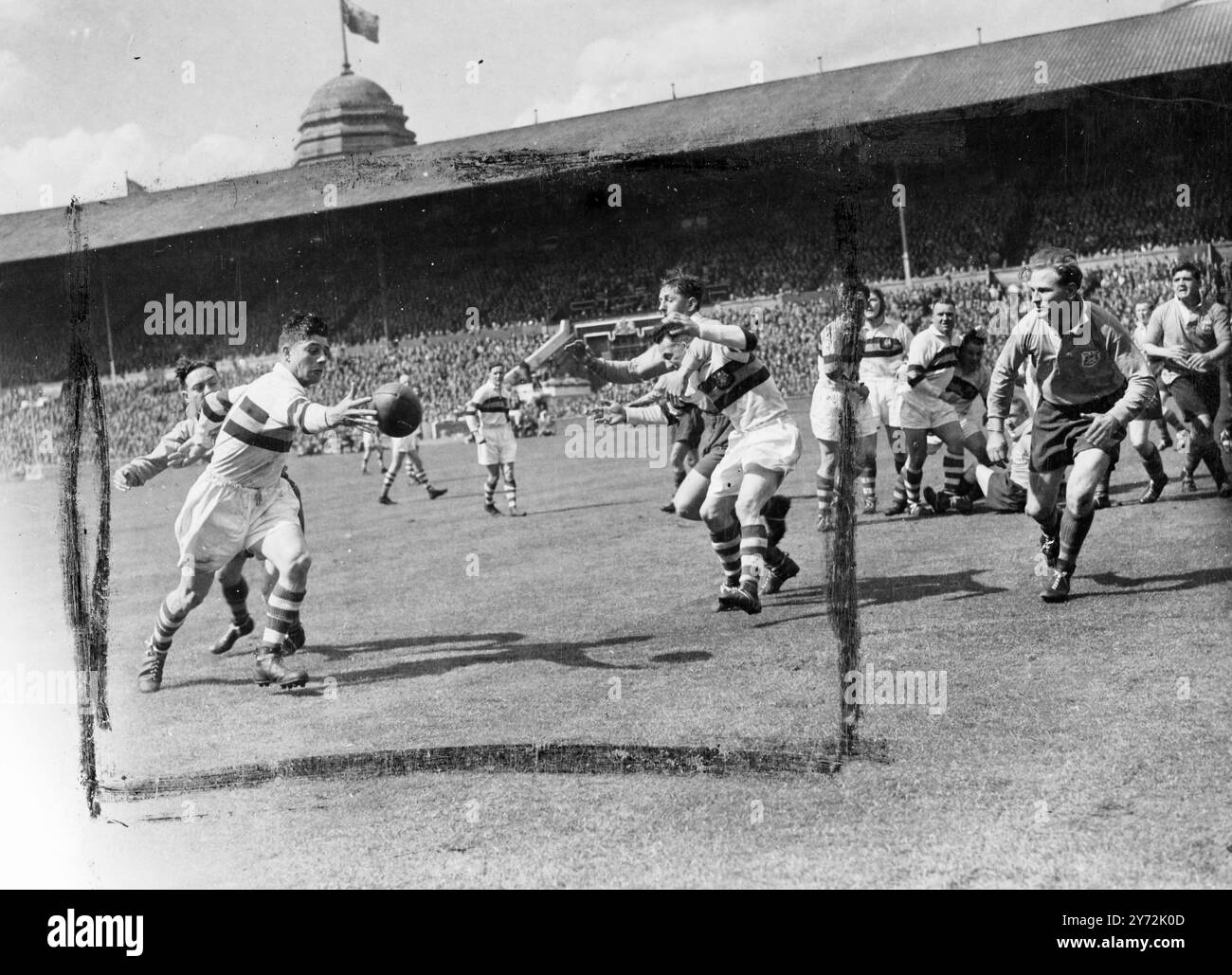 Royalty ha partecipato al Rugby Union Match al Wembley Stadium, per la prima volta quando il Leeds ha incontrato Bradford Northern nella finale di Coppa di rugby a 13. Il Duca e la Duchessa di Gloucester si stringono la mano ai giocatori prima del calcio d'inizio, e poi guardano la partita prima di presentare la coppa alla squadra vincente. Immagini: Un giocatore del Bradford Northern (pantaloncini bianchi) afferra per un passaggio mentre il gioco si trova nella metà del campo di Leeds, all'inizio della partita a Wembley. 3 maggio 1947 Foto Stock