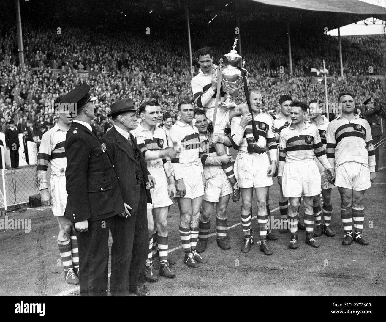 Royalty ha partecipato al Rugby Union Match al Wembley Stadium, per la prima volta quando il Leeds ha incontrato Bradford Northern nella finale di Coppa di rugby a 13. Il Duca e la Duchessa di Gloucester si stringono la mano ai giocatori prima del calcio d'inizio, e poi guardano la partita prima di presentare la coppa alla squadra vincente. Immagini: La squadra vincitrice Bradford Northern spalla il capitano dopo aver ricevuto la coppa dal Duke Gloucester a Wembley. 3 maggio 1947 Foto Stock