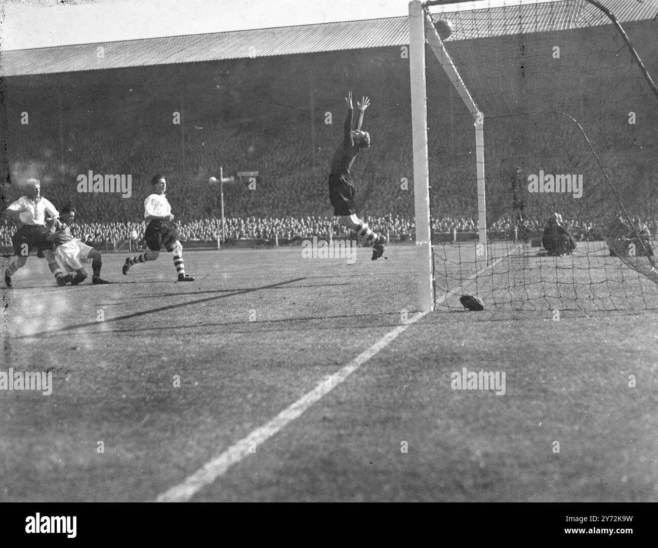 Lo stadio di Wembley era pieno di più di 90.000 spettatori, molti dei quali erano andati a Londra da nord, per la finale di fa Cup, la più grande anche nel calcio britannico, tra Charlton e Burnley. Prima della partita i giocatori sono presentati a RH il Duca di Gloucester, le medaglie di coppa per entrambe le squadre sono state presentate da RH la Dutchessa di Gloucester. Le immagini mostrano: Bartram che salta in alto, il portiere del Charlton, fa un grande salvataggio da Burnley all'interno di Morris durante le prime fasi della finale di coppa nel pomeriggio di Wembley. 26 aprile 1947 Foto Stock