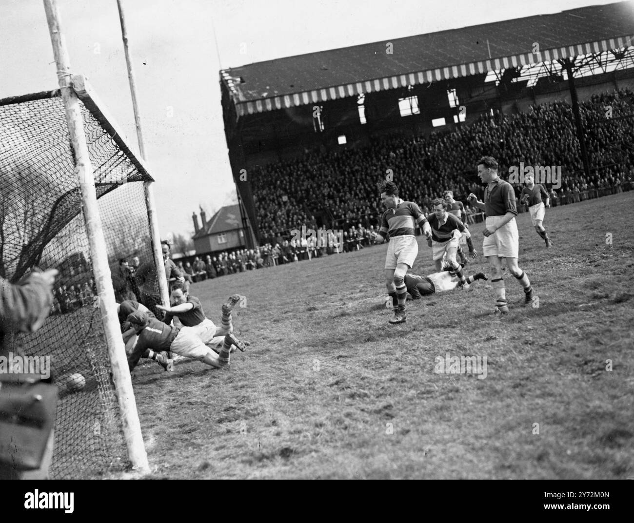 20.000 spettatori, la maggior parte degli irlandesi, sono arrivati oggi allo stadio Mitchum per vedere il lunedì di Pasqua vincere la partita di calcio tra Kerry, campioni di calcio gaelico irlandese e detentori del Cavan dell'associazione benefica londinese. La palla è stata lanciata in gioco da sua Eminenza Cardinale Griffin, Arcivescovo di Westminster. Le regole del gioco richiedono un lungo apprendistato di studio. I giocatori possono gestire la palla, ma non è consentito affrontare come nel rugby. Tiri in porta segnando 3 punti, quelli sopra la traversa un punto. Il gioco è tipicamente irlandese nella sua durezza; ogni squadra porta 3 uomini di riserva in caso di Foto Stock