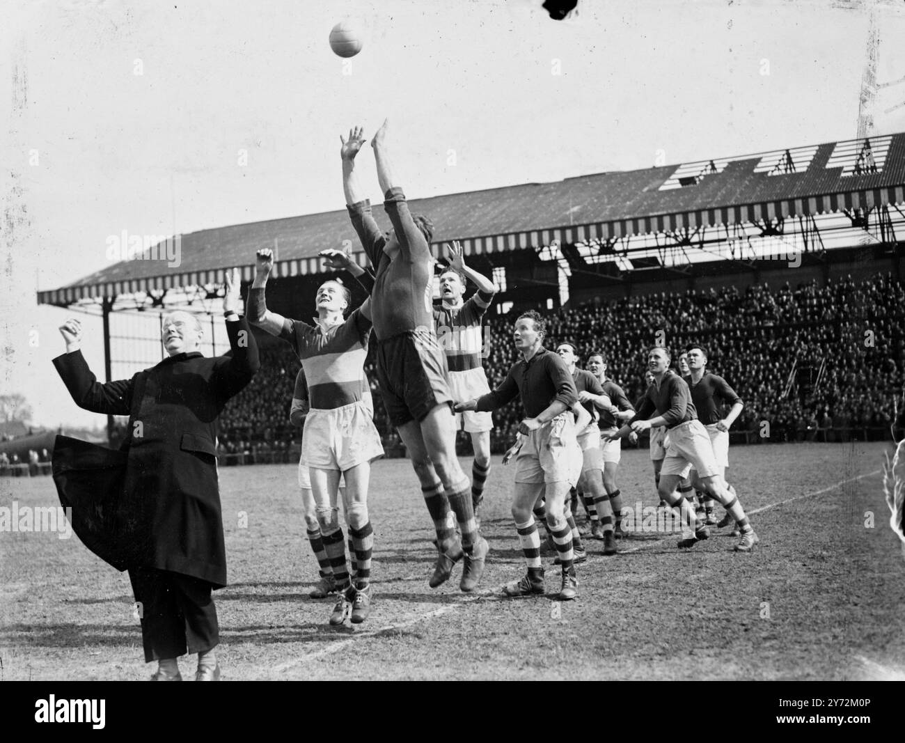 20.000 spettatori, la maggior parte degli irlandesi, sono arrivati oggi allo stadio Mitchum per vedere il lunedì di Pasqua vincere la partita di calcio tra Kerry, campioni di calcio gaelico irlandese e detentori del Cavan dell'associazione benefica londinese. La palla è stata lanciata in gioco da sua Eminenza Cardinale Griffin, Arcivescovo di Westminster. Le regole del gioco richiedono un lungo apprendistato di studio. I giocatori possono gestire la palla, ma non è consentito affrontare come nel rugby. Tiri in porta segnando 3 punti, quelli sopra la traversa un punto. Il gioco è tipicamente irlandese nella sua durezza; ogni squadra porta 3 uomini di riserva in caso di Foto Stock