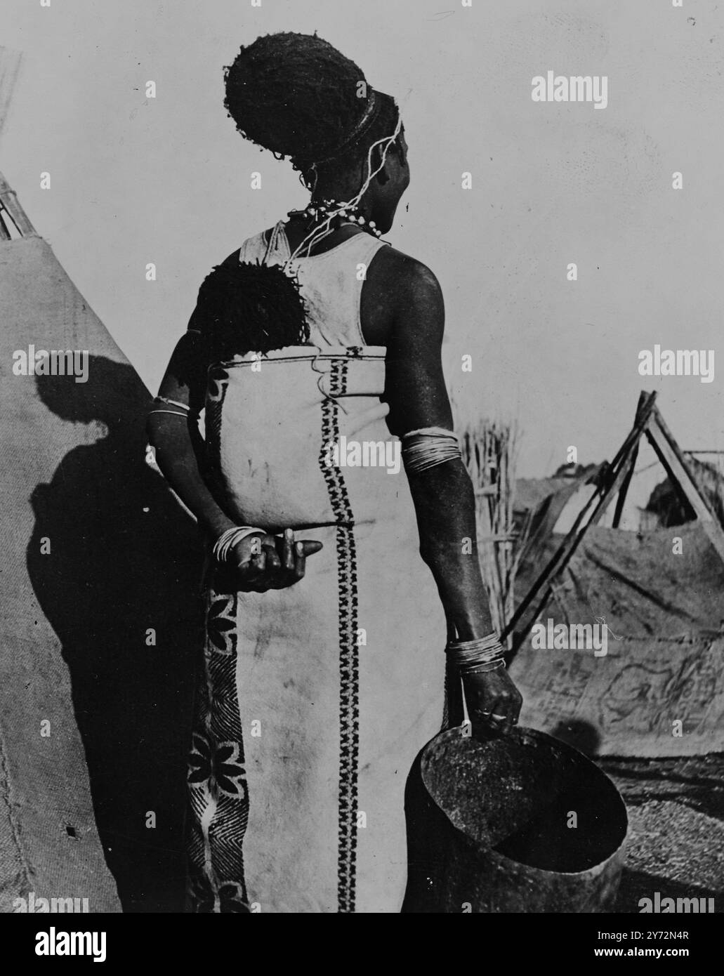 Una tenda, pentole da cucina, un elegante parrucchiere e un bambino che si è buttato dietro e la vita è completa di una donna africana che squatter. La sua vita è dura, ma almeno ha una casa tutta sua dopo mesi nelle baraccopoli sovraffollate di Johannesburg. 12 marzo 1947 Foto Stock
