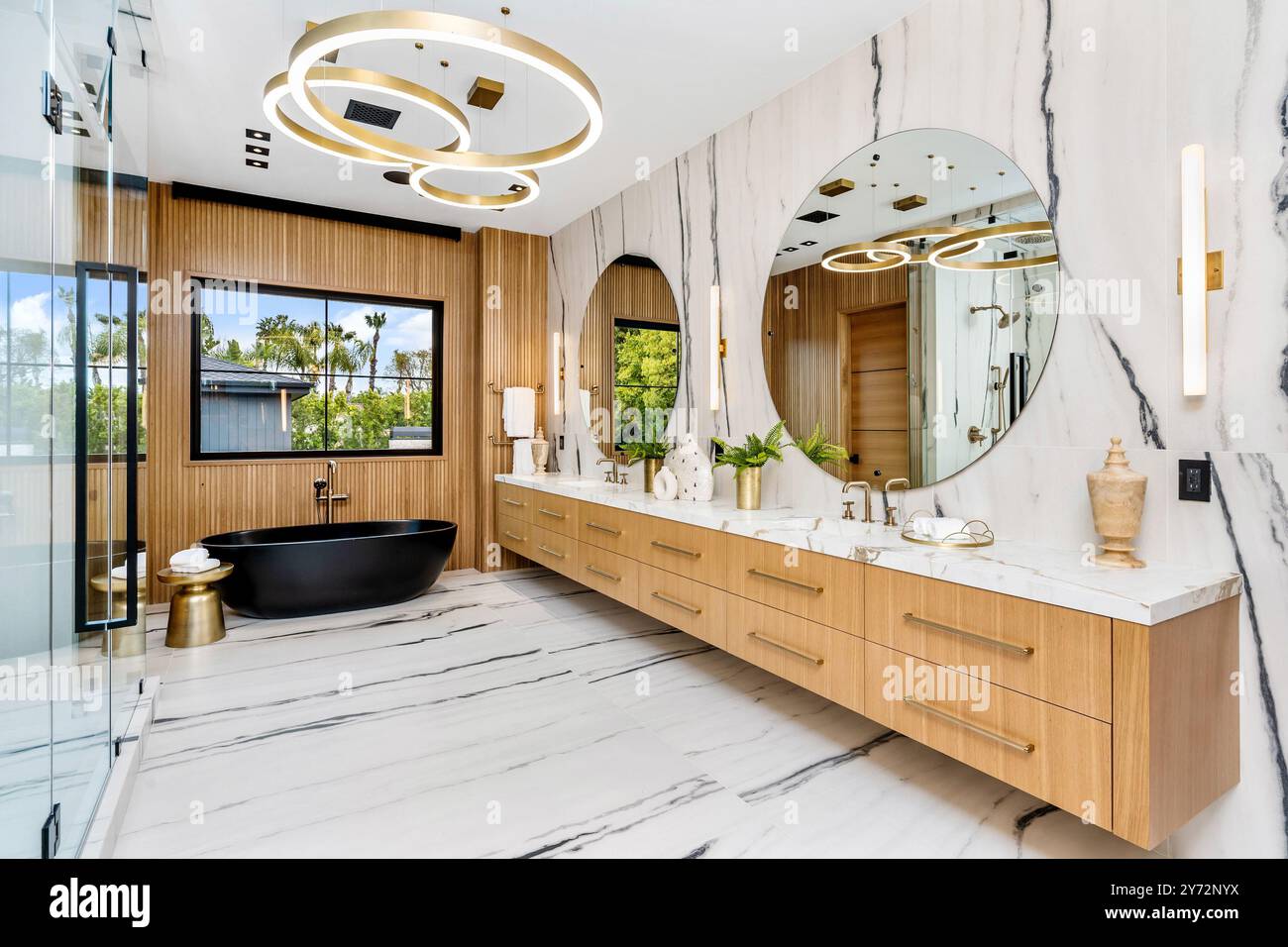 Un bagno moderno di lusso con vasca nera ed elegante pavimento in marmo. Foto Stock