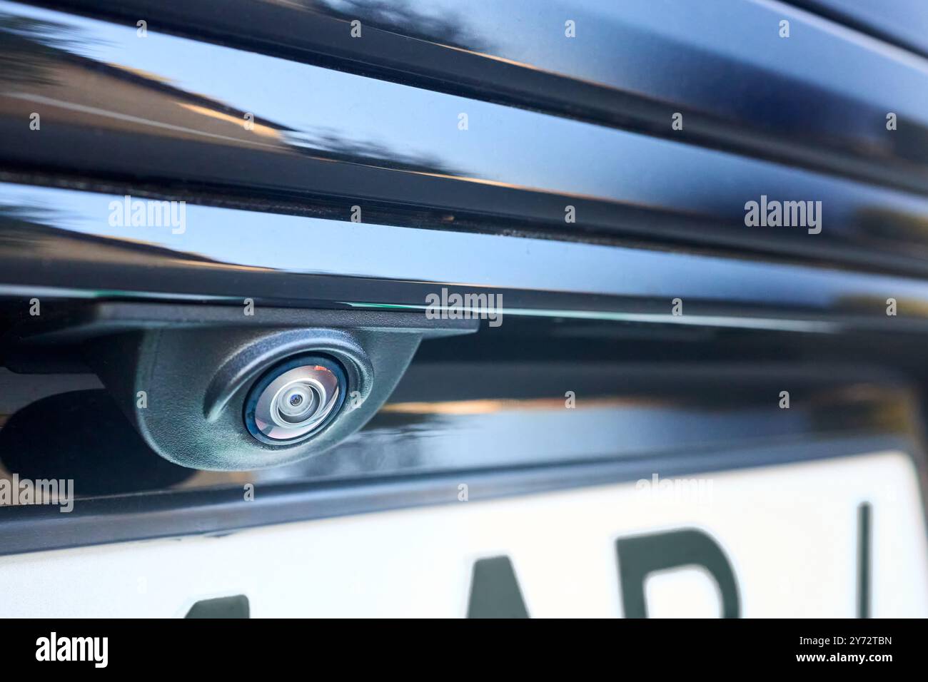 Telecamera per la visione posteriore dell'auto, sensore di parcheggio, accessorio retromarcia, nuova Spycam del veicolo con gocce d'acqua. Primo piano della telecamera posteriore di un'auto di lusso per il parcheggio automatico Foto Stock