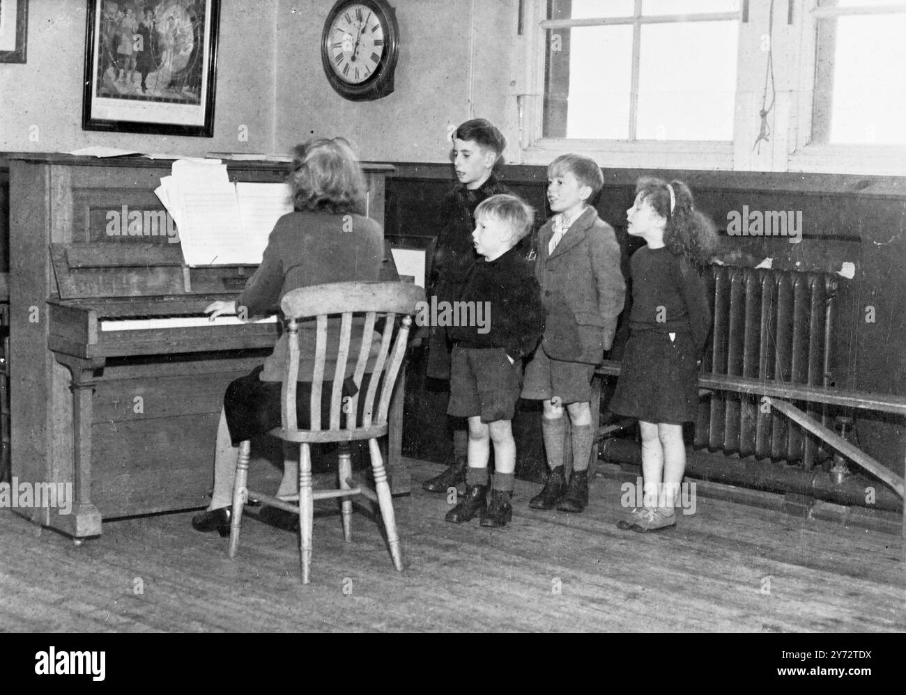 Chiamare il rotolo alla scuola del villaggio con tetto rosso di Newham, Northumberland è una questione molto semplice. Solo quattro nomi appaiono sul registro e la scuola che nel 1907 è stata costruita per ospitare 72 alunni. Da quando il tasso di natalità è diminuito e l'introduzione di macchinari nelle aziende limitrofe ha fatto sì che il numero di alunni si abbassasse sempre di più. Immagini: La scuola completa si riunisce per una lezione di canto popolare. 27 novembre 1946 Foto Stock