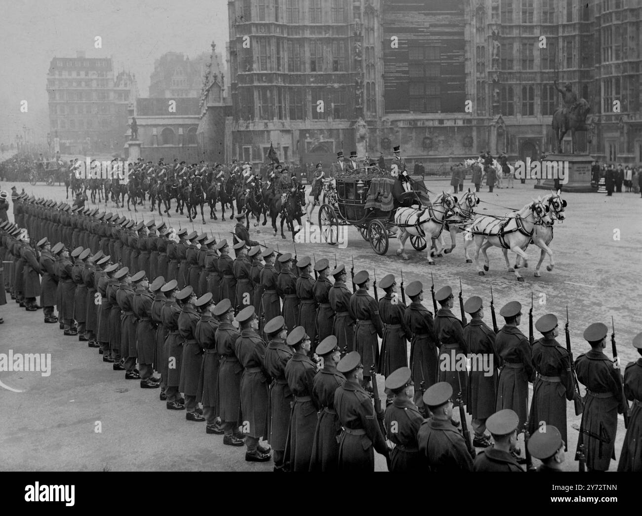 Il re e la regina si recarono nello stato da Buckingham Palace alla camera dei lord per l'apertura del Parlamento. Le loro maestose furono scortate da una scorta di Capitano di Household Cavalry e prima del Royal Coach c'era una carrozza contenente le corone. Alla Victoria Tower, Westminster il re e la regina furono incontrati dai grandi uffici di stato e procedettero verso la Robing Room. Per salutare il loro arrivo a Westminster, una truppa della Royal Horse Artillery sparò 41 t di cannoni da St James's Park. La foto mostra: La processione reale che arriva alle camere del Parlamento per l'apertura dello stato. 12 novembre 194 Foto Stock