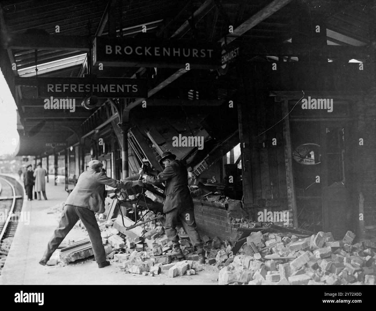 14 persone sono rimaste ferite, una sala ristoro è andata distrutta e due carrozze di un Weymouth-London Express sono state danneggiate quando una bombola di gas è esplosa alla stazione di Brockenhurst. Mentre il treno entrava nella stazione, una bomba come un'esplosione affittava l'aria. Le persone nel buffet e i passeggeri del treno sono rimasti feriti dal vetro volante, e le vittime sono state trasferite al Lymington Hospital. L'immagine mostra la rimozione dei detriti dalla stanza di ristoro in rovina alla stazione di Brockenhurst - una scena che ricorda le bombe incidentyeah del football. 21 ottobre 1946 Foto Stock