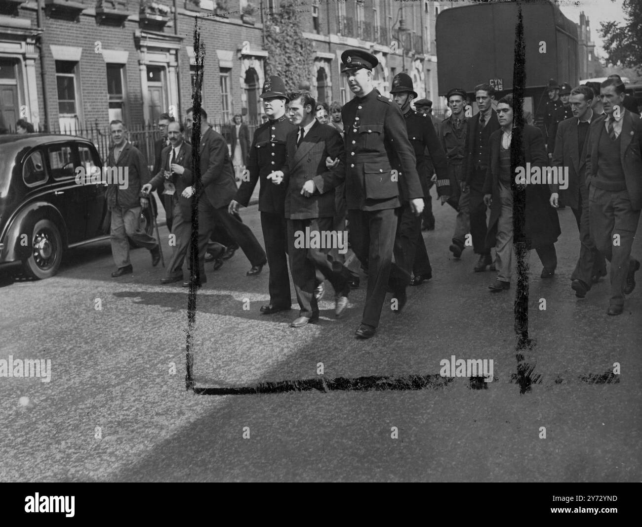 Un uomo e' stato arrestato fuori dall'hotel Ivanhoe, Bloomsbury, ed e' stato scortato alla stazione di polizia di Tottenham Court Road stamattina. L'hotel Ivanhoe e' stato preso da "squatters" ieri sera. Immagini: L'uomo arrestato viene portato via dagli agenti di polizia. 11 settembre 1946 Foto Stock