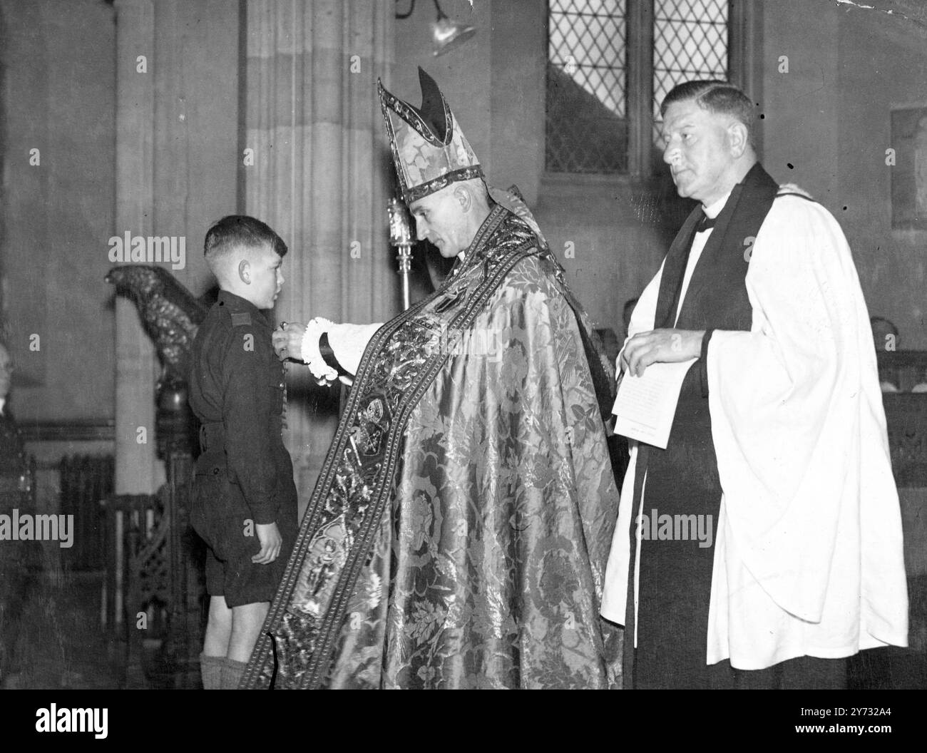 Ragazzo valoroso onorato al servizio della chiesa. Quando il Vescovo di Monmouth presentò la Gallant Conduct Medal della Church Lads Brigade al decenne Robert Harris, di Crindu, Newport, durante un servizio presso la All Saints Church, Newport, Men, disse che era la prima volta che aveva assistito a una "cerimonia del genere" interpolata in un servizio della Chiesa. Il ragazzo, un non nuotatore, ricevette la decorazione per il suo coraggio nel salvare una bambina di tre anni, che era caduta nel fiume Ebb a Newport. La foto mostra il vescovo di Monmouth (il Rev Alfred Edwin Morris di destra) che ha vinto la medaglia su Robert H. Foto Stock