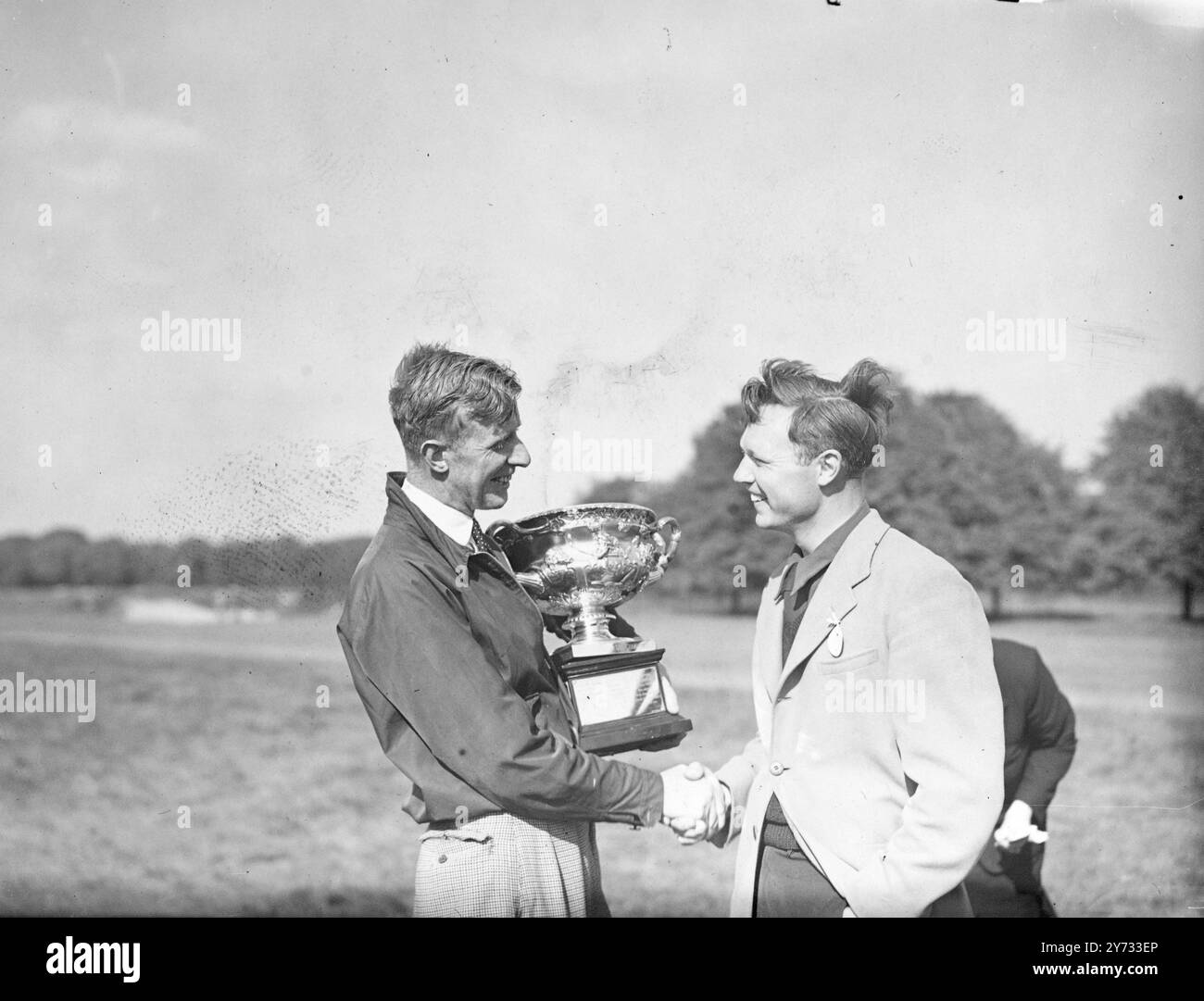 Ian Patey e Kenneth Thom hanno partecipato alla finale dell'English Amateur Golf Championship sul Royal Mid-Surrey Club's Course di Richmond. L'immagine mostra il vincitore Ian Patey, che tiene la coppa mentre stringe la mano a Thom dopo la partita. 4 maggio 1946 Foto Stock