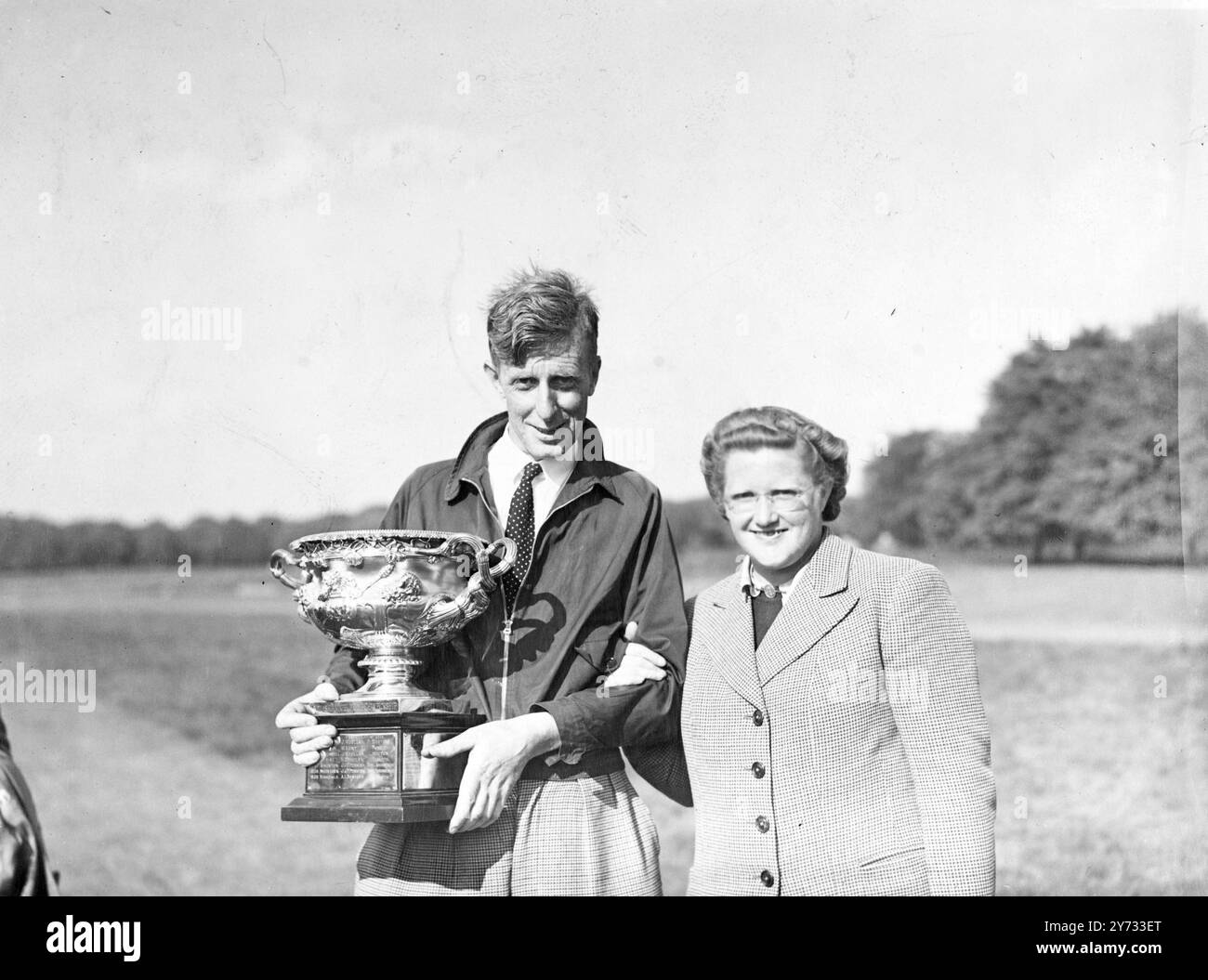 Ian Patey e Kenneth Thom hanno partecipato alla finale dell'English Amateur Golf Championship sul Royal Mid-Surrey Club's Course di Richmond. La foto mostra il vincitore Ian Patey, che tiene la coppa dopo la vittoria, accompagnato da sua moglie. 4 maggio 1946 Foto Stock