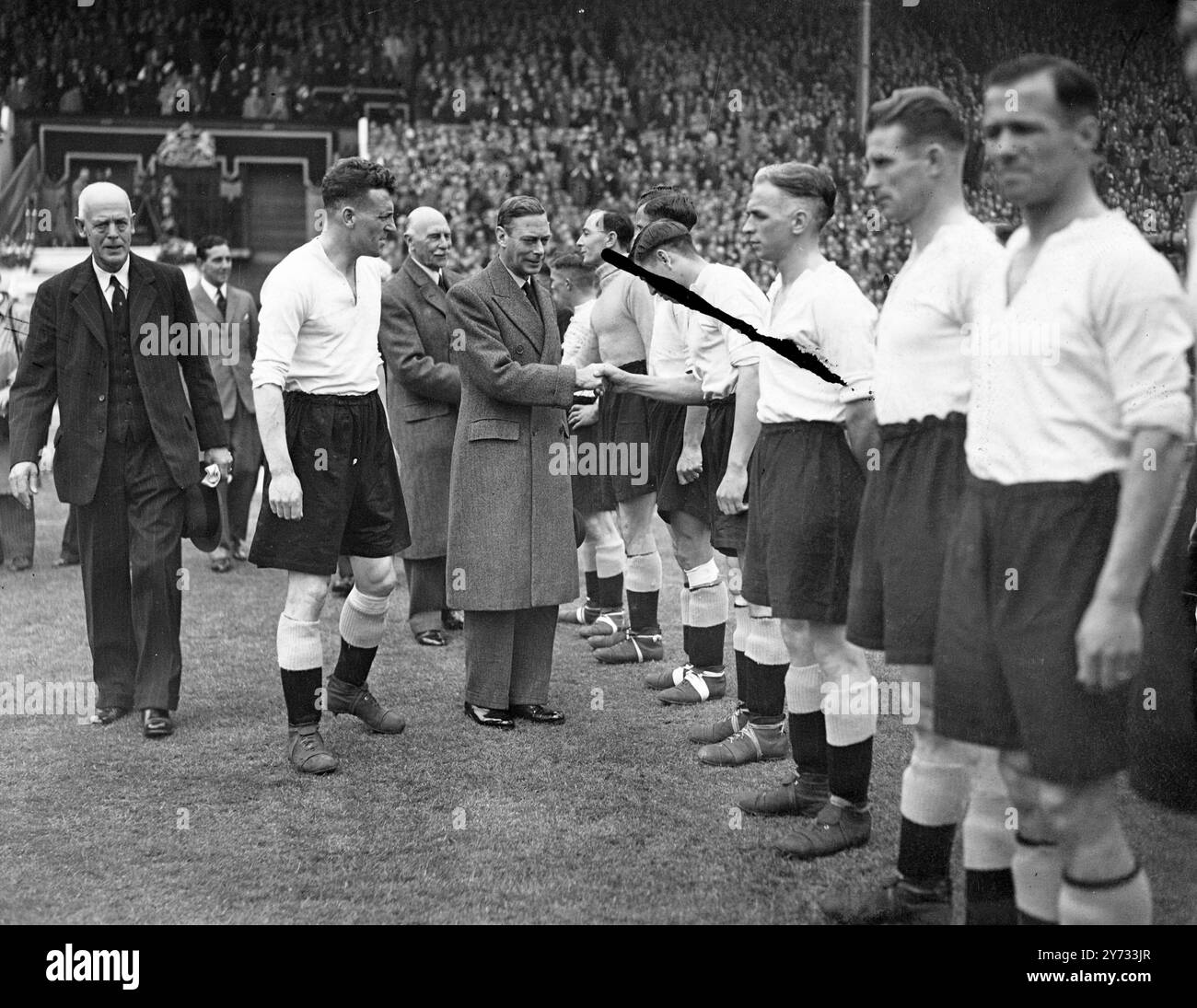 Le loro maestose King e Queen con sua altezza reale la Principessa Elizabeth, erano presenti alla finale di fa Cup al Wembley Stadium tra Derby County e Charlton Athletic. I giocatori sono stati presentati al re prima dell'inizio del gioco. La foto mostra che il re stringe la mano al lato della contea di Derby prima della partita. 27 aprile 1946 Foto Stock