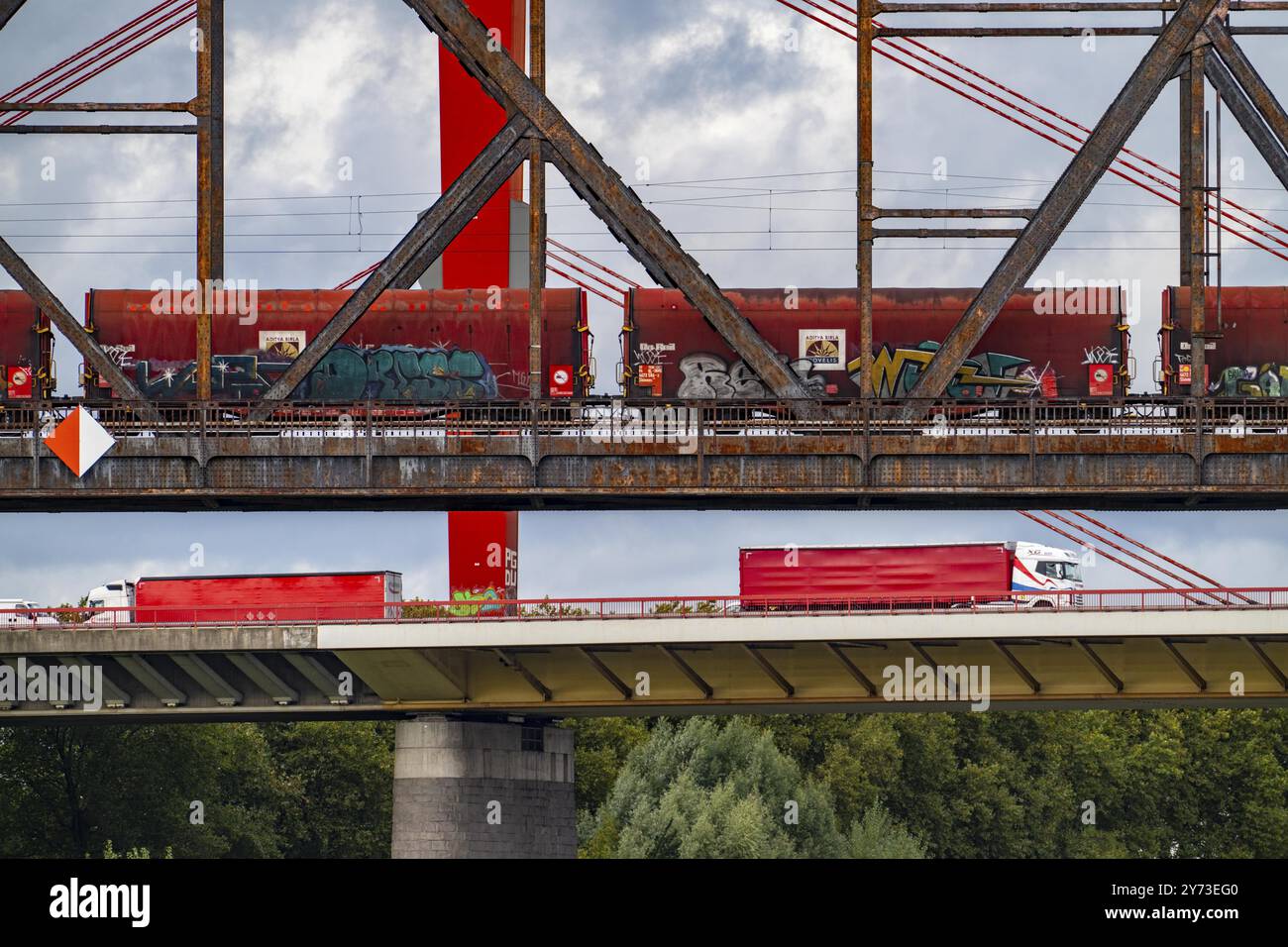 Il ponte Beeckerwerth Reno dell'autostrada A42, traffico di camion, di fronte al ponte ferroviario Haus-Knipp, treno merci, Reno vicino a Duisburg, Nort Foto Stock