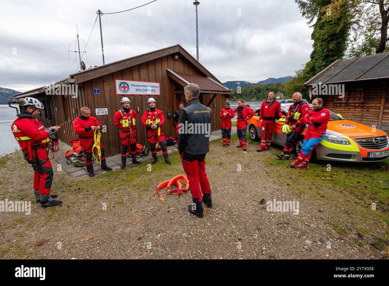 Walchensee, Germania. 27 settembre 2024. I membri dello squadrone di elicotteri di salvataggio ADAC e della squadra di salvataggio in acqua DLRG prendono parte all'addestramento di dispiegamento del verricello a Walchensee. Crediti: Peter Kneffel/dpa/Alamy Live News Foto Stock