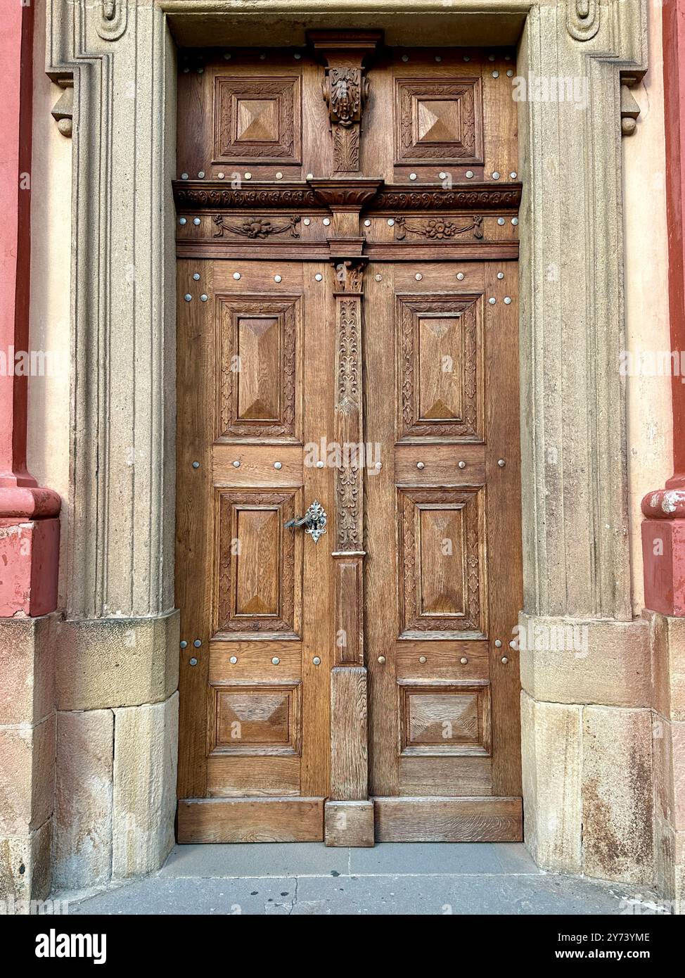 La fotografia cattura una vista dettagliata di un antico cancello medievale in legno e metallo, situato nelle strade di una storica città europea. Foto Stock