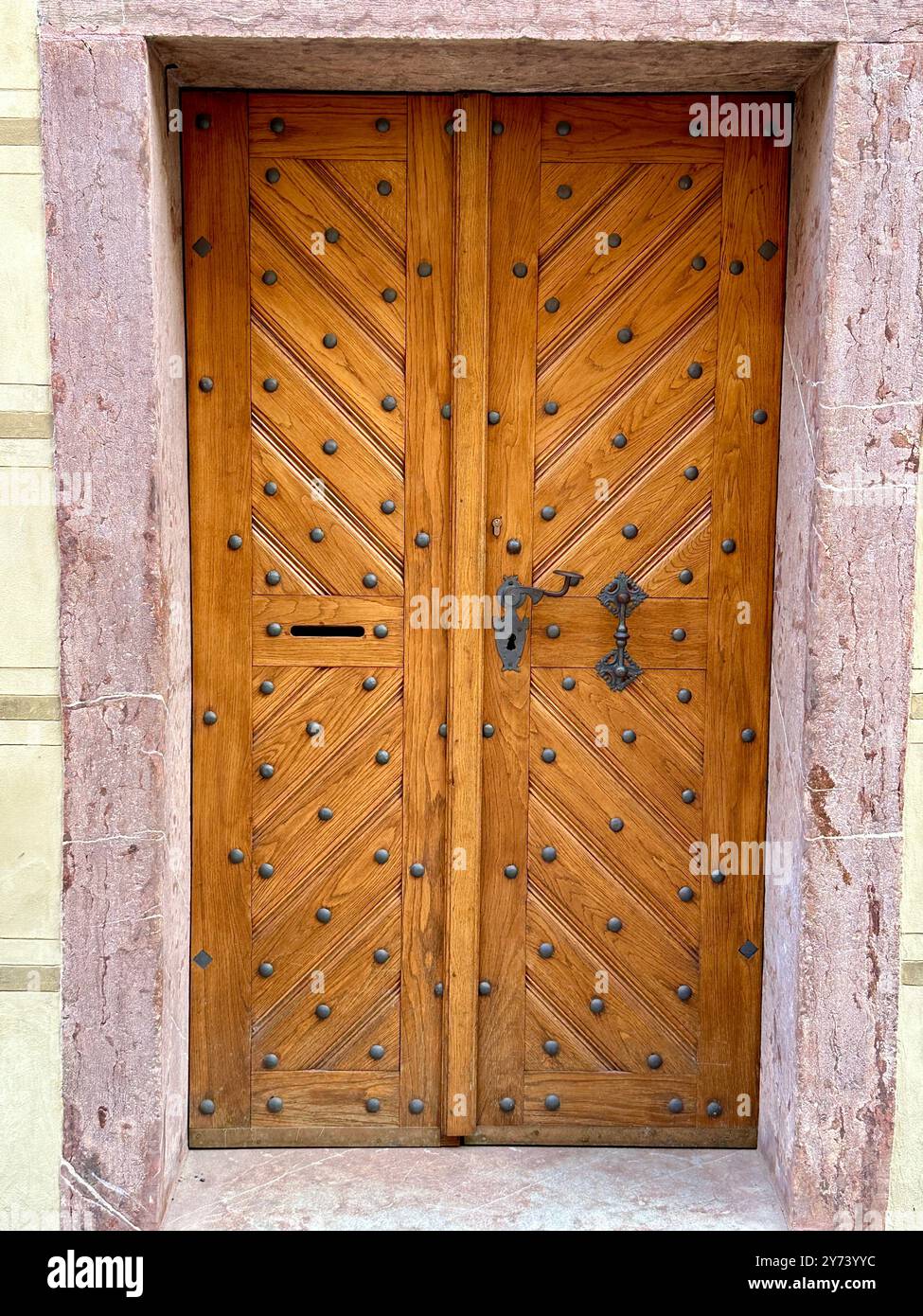 La fotografia cattura una vista dettagliata di un antico cancello medievale in legno e metallo, situato nelle strade di una storica città europea. Foto Stock