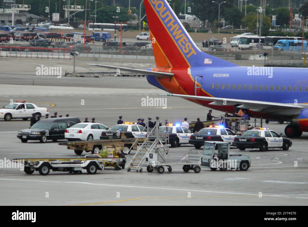 ChatGPT scorta di polizia e risposta di emergenza in pista aeroporto che coinvolge veicoli e personale delle forze dell'ordine vicino a un aereo Southwest Airlines in A. Foto Stock