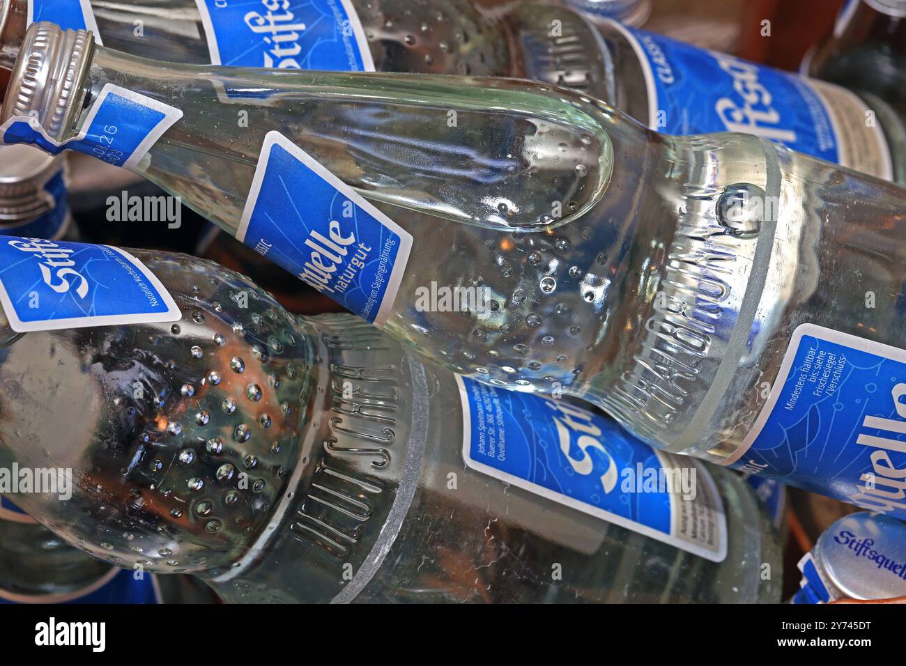 Getränkeflaschen aus Glas in einer Getränkekiste befinden sich Normbrunnenflaschen mit Mineralwasser aus Glas zur mehrfachen Verwendung. *** Bottiglie di vetro Per bevande Una cassa per bevande contiene bottiglie standard per fontane con acqua minerale di vetro per uso multiplo Foto Stock