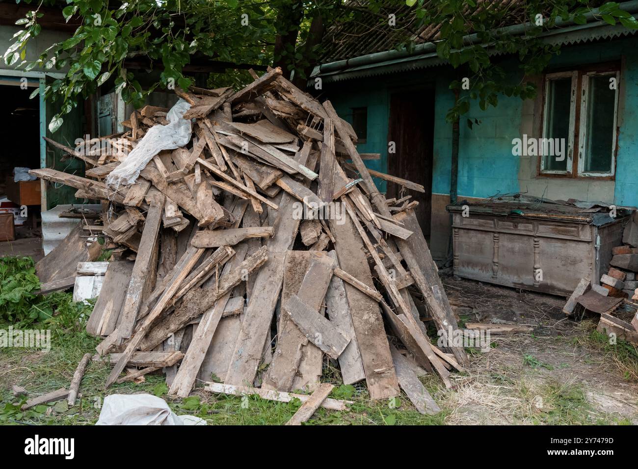 Un palo rustico di tavole di legno e detriti, circondato da una vegetazione lussureggiante. Foto Stock