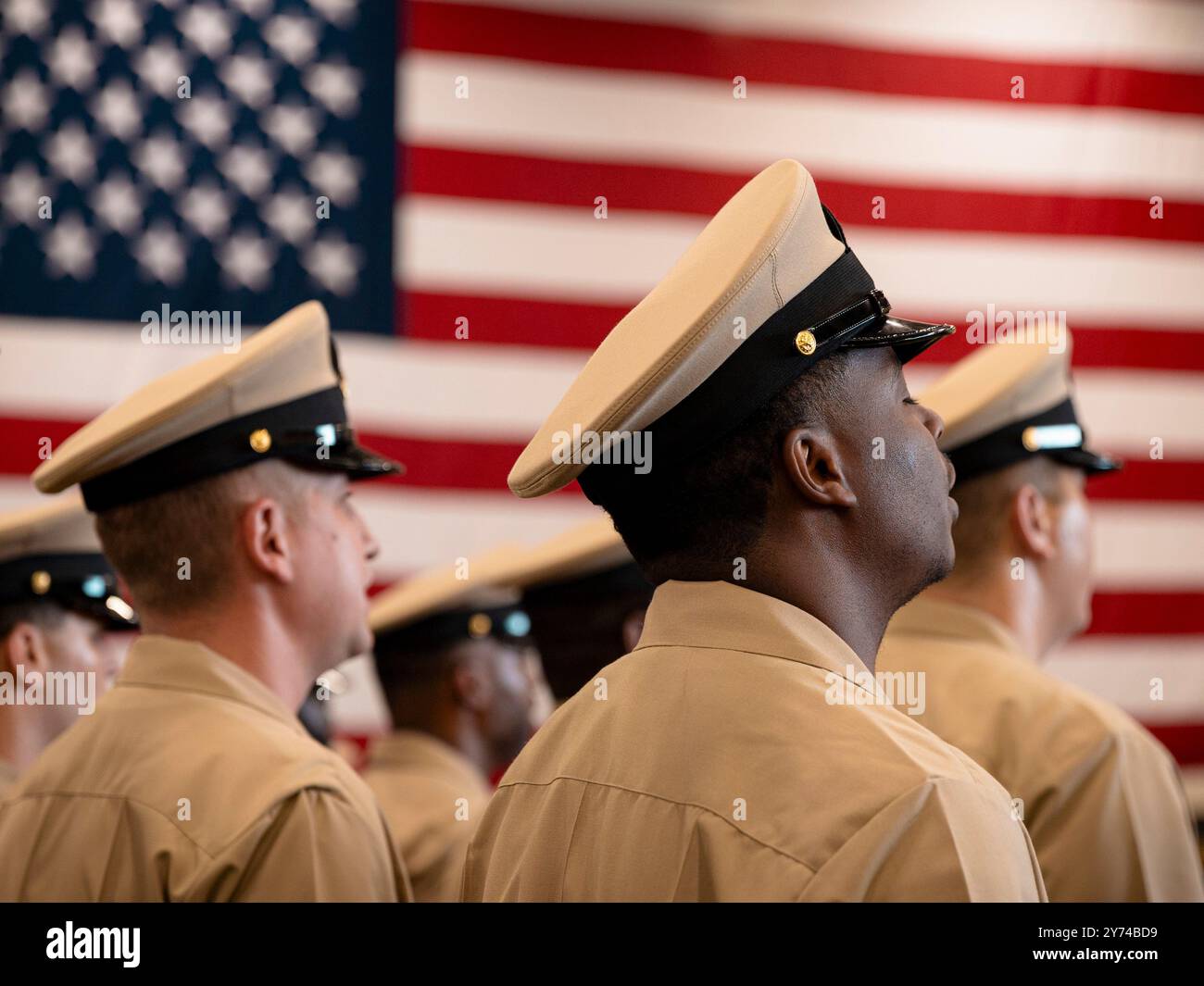 NORFOLK, V.A. (27 settembre 2024) Chief Petty Officers, assegnati alla più grande portaerei del mondo, la USS Gerald R. Ford (CVN 78), canta Anchors Aweigh durante la conclusione di una cerimonia di pinning Chief Petty Officer nella baia dell'hangar, 27 settembre 2024. Ford è attualmente al molo presso la Naval Station Norfolk che conduce la manutenzione di routine. (Foto della Marina degli Stati Uniti dello specialista di comunicazione di massa Seaman Tajh Payne) Foto Stock