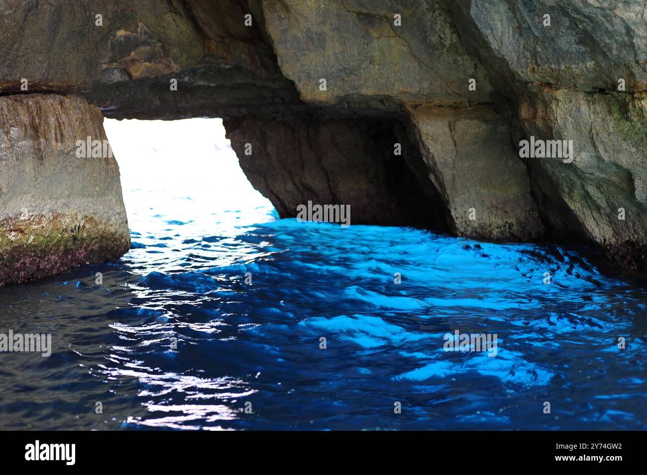 L'acqua di mare riflette sfumature di incredibilmente blu nella Grotta della finestra Azzurra situata nel complesso delle grotte della Grotta Azzurra a Malta. Uno dei più pop Foto Stock