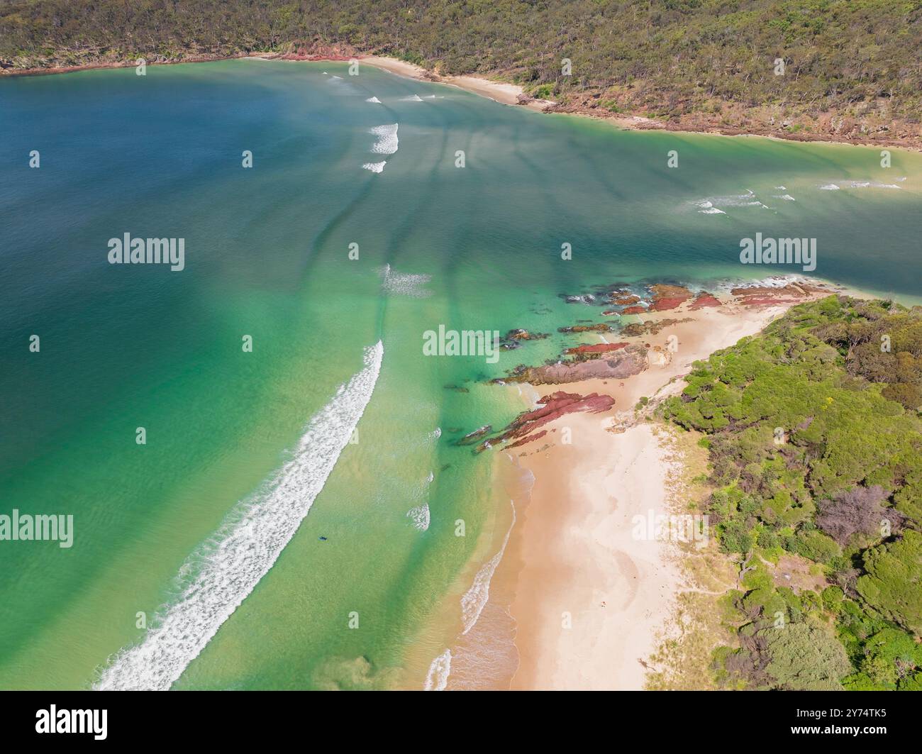Vista aerea dell'oceano turchese intorno a un fiume che scorre oltre le spiagge sabbiose di Pambula Beach nel New Southern Wales, Australia. Foto Stock
