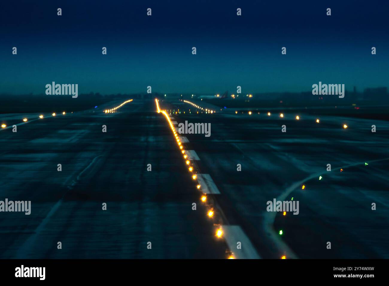 Immagine sfocata della pista dell'aeroporto illuminata al crepuscolo Foto Stock