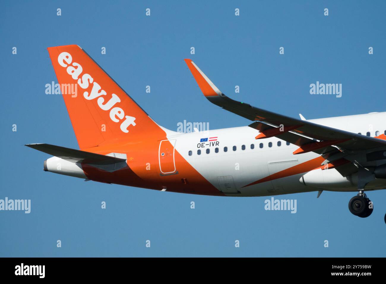 EasyJet Plane Tail fin Logo Aircraft atterraggio aeroplano Jetliner passeggero Jet Airliner Air Airbus A320 su Blue Sky Foto Stock