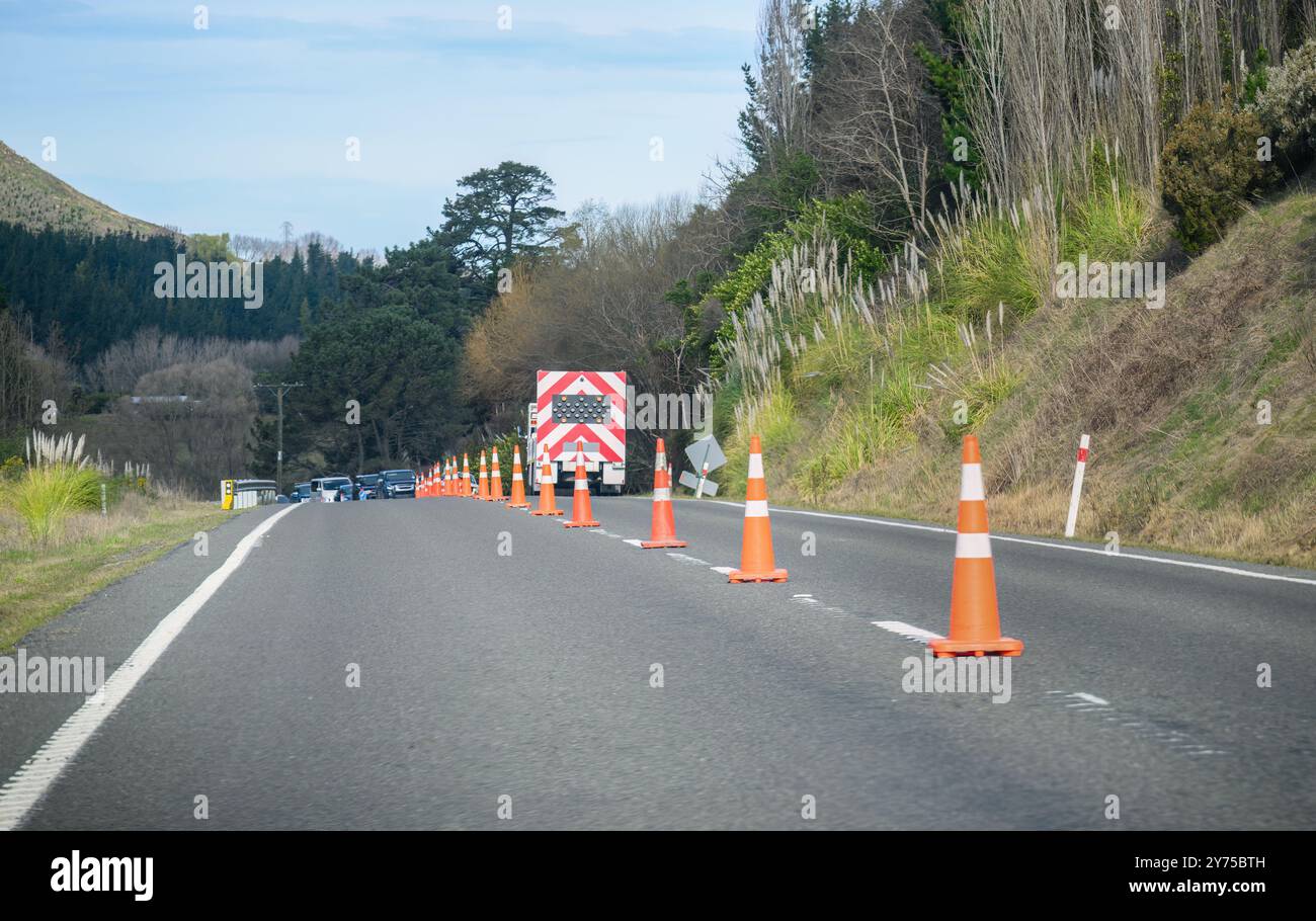 Coni stradali arancioni sulla strada. Macchine fermate dal camion. Lavori stradali a Hawke's Bay. Nuova Zelanda. Foto Stock