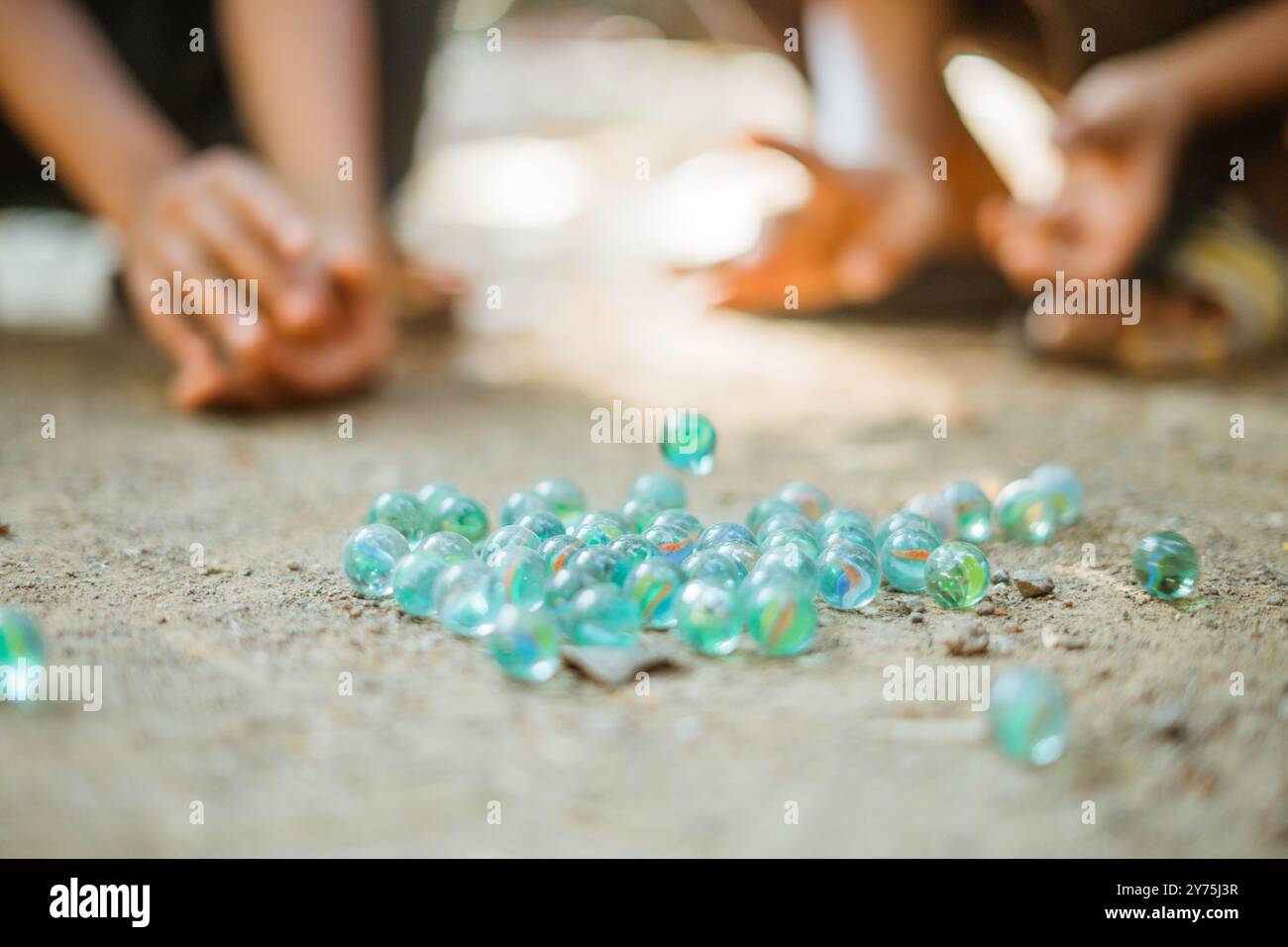 i bambini colpiscono a mano biglie per terra Foto Stock