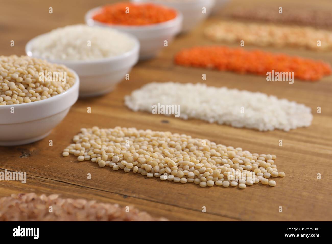 Diversi tipi di cereali e legumi su tavola di legno, primo piano Foto Stock