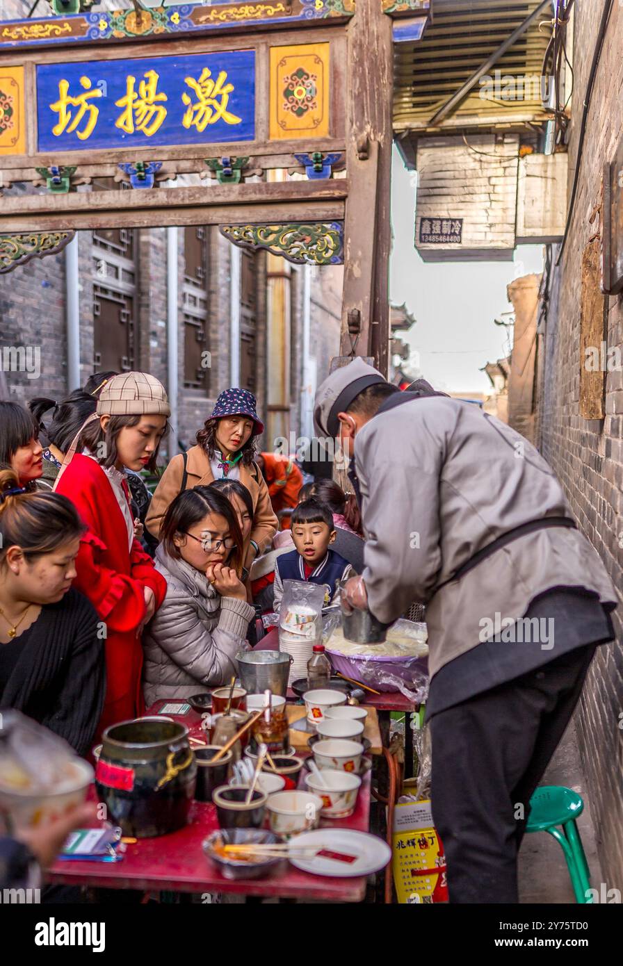 Venditori di cibo di strada e folla per le strade di Pingyao, in Cina Foto Stock