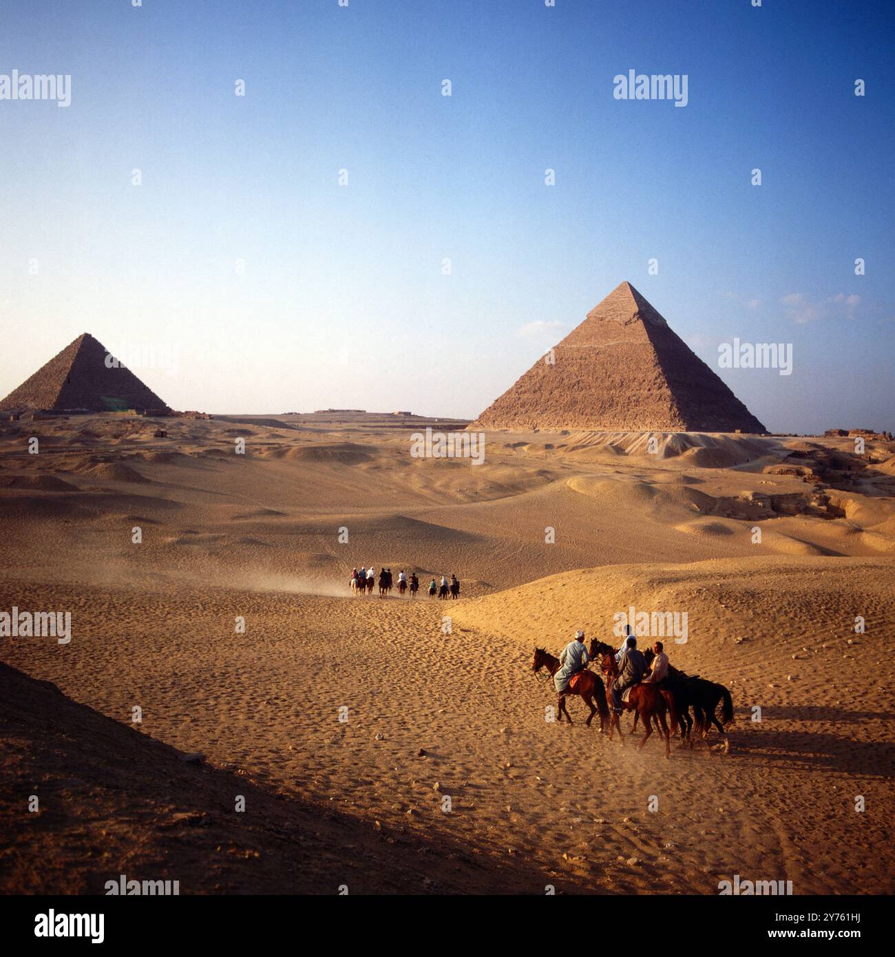 Touristengruppen bei einem Ausritt zwischen den Pyramiden des Mykerinos (links) und des Chephren auf dem Pyramidenplateau in Gizeh, Ägypten um 1987. Foto Stock