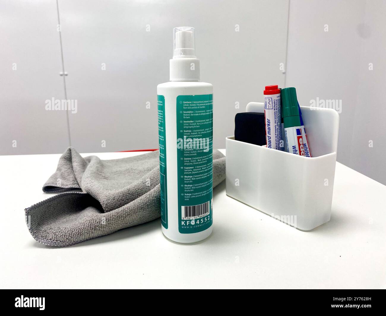Penne per lavagna bianca, flacone di liquido detergente e panno su un piano bianco in un ufficio. - Immagine stock catturata con smartphone