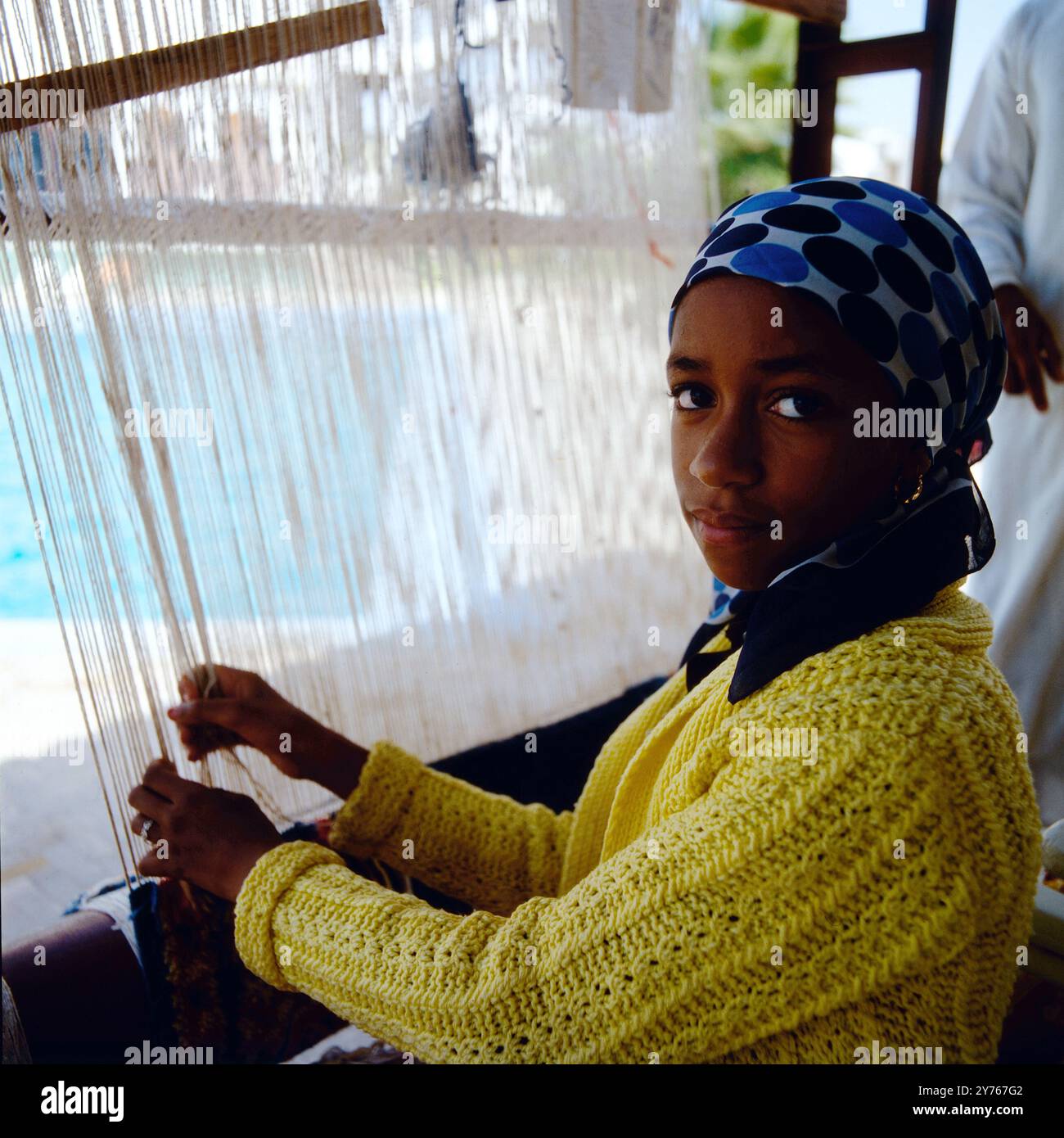 Mädchen beim Teppichweben, Marokko um 1985. Foto Stock