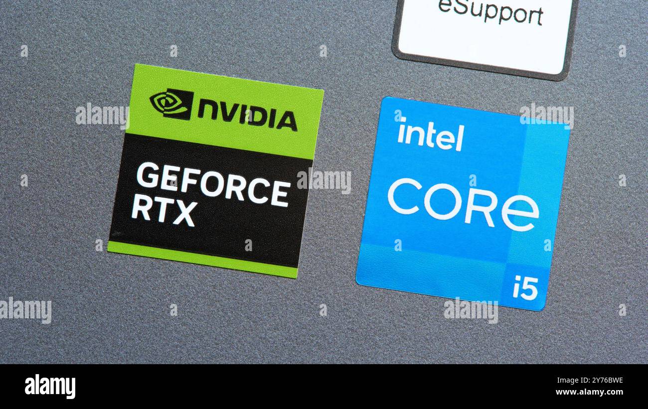 Il produttore della GPU NVIDIA GeForce RTX e della CPU Intel Core applica le etichette su un computer portatile, primo piano delle macro. Scheda grafica e processore in una console Foto Stock